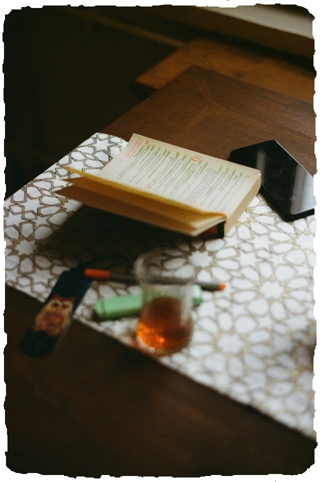 a cup of roobois tea and a book on the table
