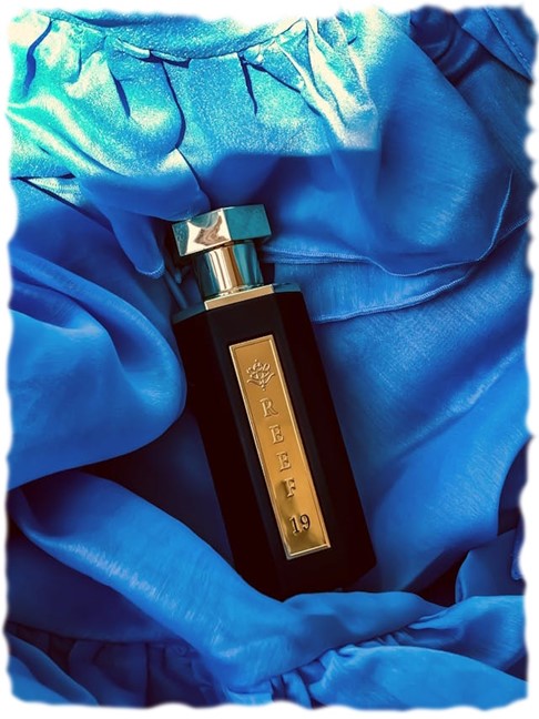 A bottle of perfume on a blue fabric. Parfume today