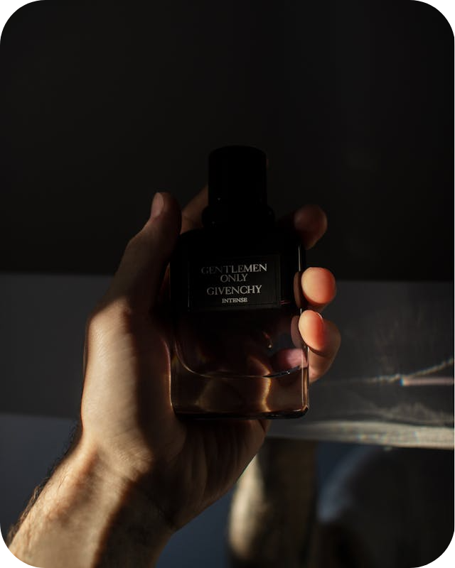 a woman holding a bottle of parfume